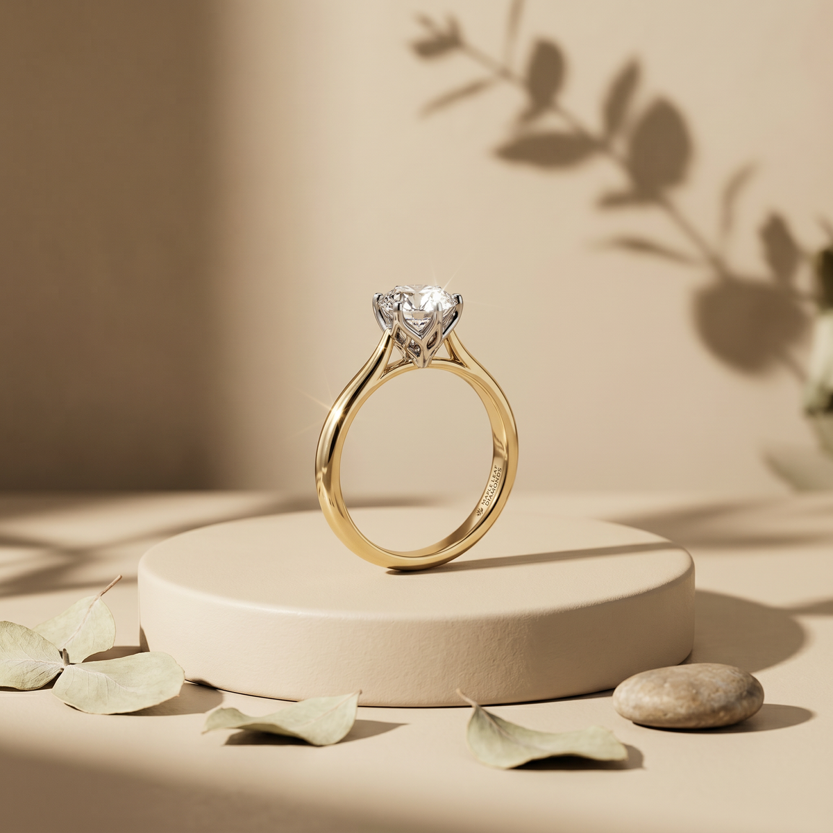 Diamond solitaire engagement ring in yellow gold on a stone plinth